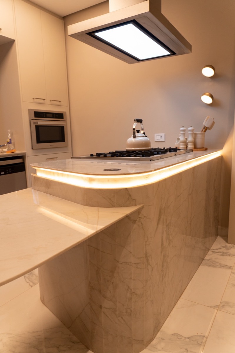Ilha curva com cooktop em Quartzito Apolo